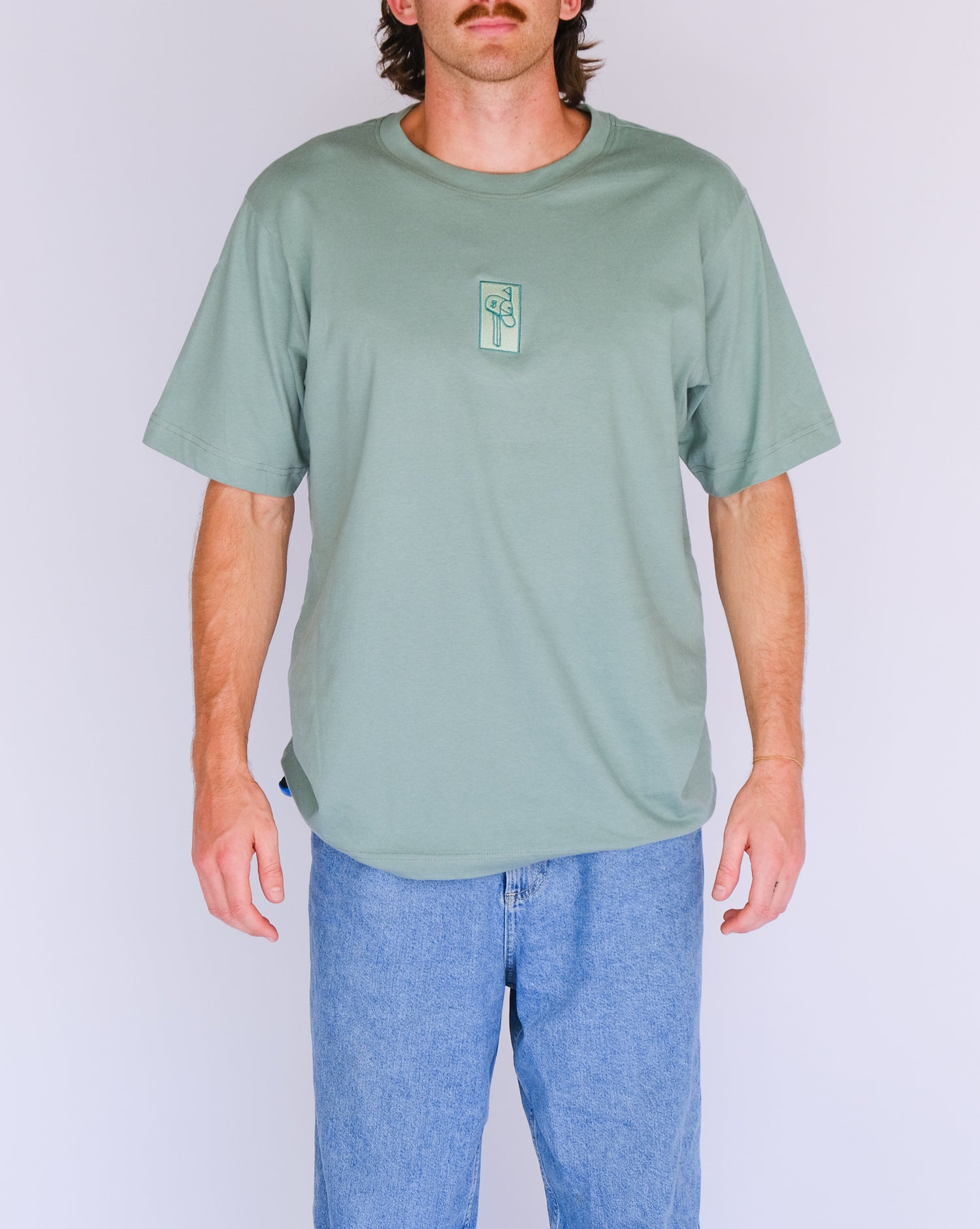 Model 1 wearing sage green letterbox tee